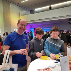 Mann mit Werbetaschen und zwei Jugendliche mit Flyern